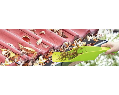 Dakgoot reinigen met een schep om bladeren te verwijderen