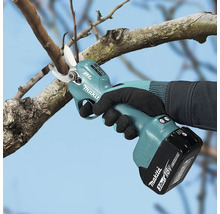 Accu-snoeischaar van Makita met koolborstelloze motor bij het snoeien van een boomtak met een 18 Volt accu.