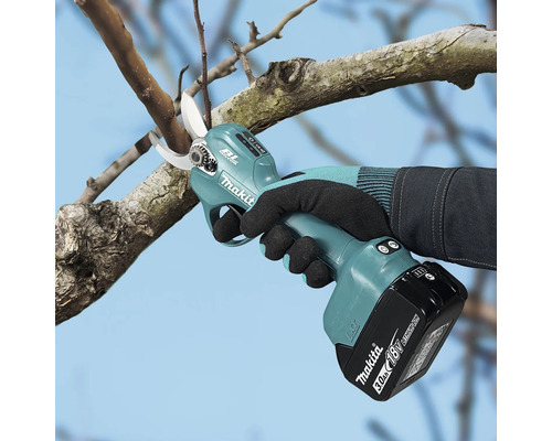 Accu-snoeischaar van Makita met koolborstelloze motor bij het snoeien van een boomtak met een 18 Volt accu.