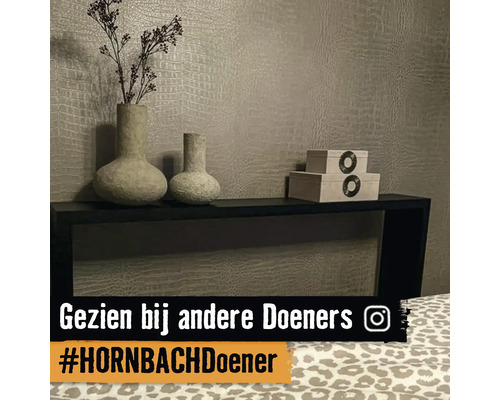 Decoratieve vazen en houten kisten op een eenvoudig zwart rek voor een gestructureerde wand.