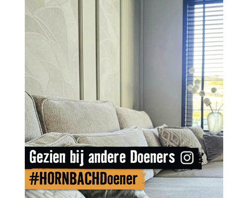 Woonkamer met bank, kussens, decoratie en bloemenbehang