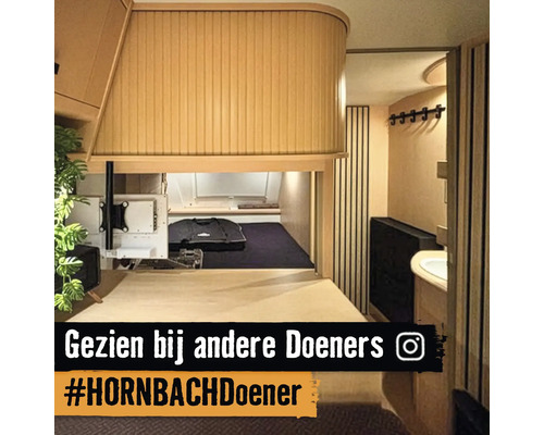 Interieur van een camper met bed, opbergruimte en badkamer