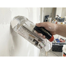 Gladde spaan Superglatt met handvat in de hand bij het pleisteren van een muur