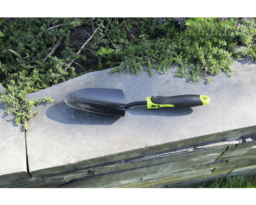 Tuinschep op een muur met planten op de achtergrond