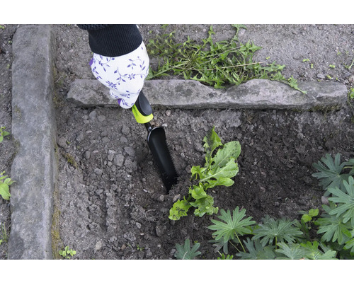 Tuinieren met een handspatel in een bloembed