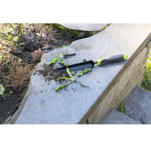 Tuiniergereedschap en onkruid op stenen trappen