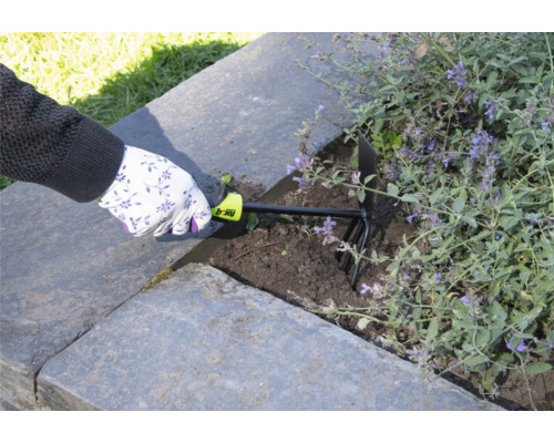 Een persoon gebruikt een tuinkrabber om de aarde in een verhoogde tuin los te maken.