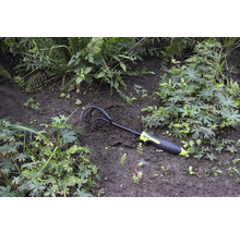 Tuinklauw in de bloembed tussen planten