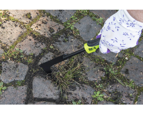 Iemand verwijdert onkruid met een voegenkrabber van for_q tussen straatstenen.