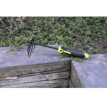 Blad- en tuinhark met tanden en kunststof handvat op stenen muur