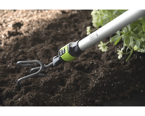Tuinklauw met steel woelt aarde los naast planten.