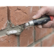 Een persoon gebruikt een Maurerlob voegspijker om mortel tussen rode bakstenen aan te brengen.