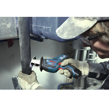 Vakman snijdt een donkere pijp door met een Bosch Professional accu-reciprozaag in een werkruimte met zilverkleurige metalen buizen.
