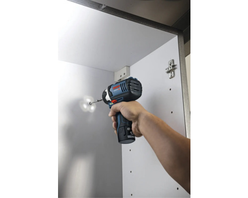 Bosch accu-slagschroevendraaier bij het indraaien van een schroef in een witte kast.