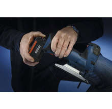 Een persoon plaatst een accu uit het Bosch Professional 18 volt systeem in een decoupeerzaag.