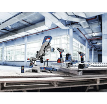 Assortiment Bosch Professional elektrisch gereedschap, waaronder een afkortzaag, accuboormachine en decoupeerzaag, in een lichte industriële hal.