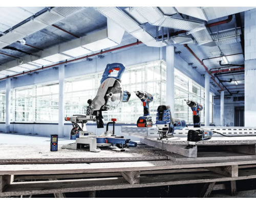 Assortiment Bosch Professional elektrisch gereedschap, waaronder een afkortzaag, accuboormachine en decoupeerzaag, in een lichte industriële hal.