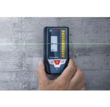 Bosch Professional LR 7 laserontvanger tegen een betonnen muur met een horizontale groene laserlijn.