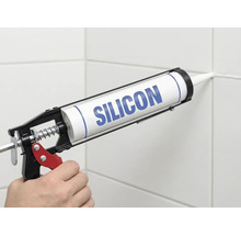 Toepassing van silicone met een kitspuit op een tegelvoeg.