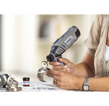 Een persoon gebruikt een Dremel 8100 accu-multitool met polijstaccessoire om een metalen armband te polijsten.