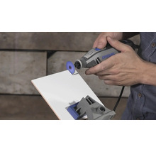 Dremel multifunctioneel gereedschap bij het snijden van een witte tegel met een doorslijpschijf.