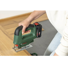 Een persoon snijdt een stuk laminaat met een Bosch accu-decoupeerzaag EasySaw 18V-70.