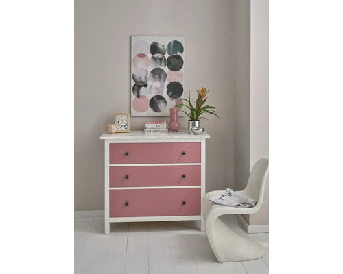 Witte ladekast met drie roze lades, marmeren blad, decoratie en abstract schilderij in een lichte, georganiseerde kamer.