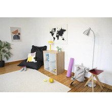 Lichte kamer met houten vloer, houten vakkenkast, zwarte zitzak, zilveren vloerlamp en licht tapijt.