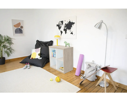 Lichte kamer met zitzak, houten kast, vloerlamp en tapijt op een houten vloer. Modern en georganiseerd ingericht.