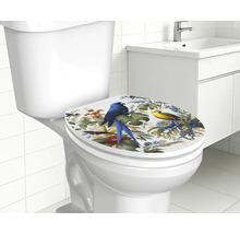Toiletzitting met tropisch motief van papegaaien en bloemen op een wit toilet in een lichte badkamer.