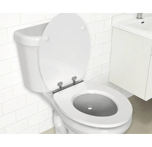 Wit staand toilet met open toiletzitting in een badkamer met witte wandtegels en een wastafelmeubel.
