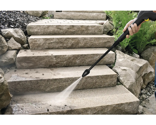 Schoonmaken van stenen trappen buiten met de waterstraal van een hogedrukreiniger.