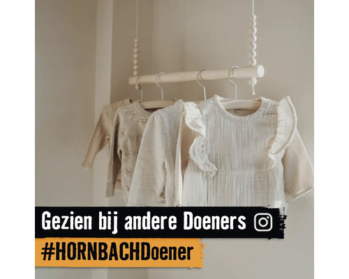 Hangende houten kledingroede met houten kralen aan touwen in een lichte babykamer, voorzien van babykleding op houten hangers. Instagram Logo.