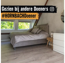 Moderne slaapkamer op zolder met gestoffeerd bed, lichte vloer met houtlook en structuurbehang.