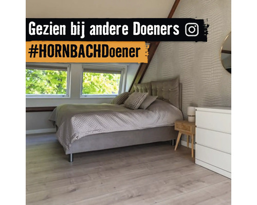 Moderne slaapkamer op zolder met gestoffeerd bed, lichte vloer met houtlook en structuurbehang.