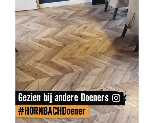 Vloerbedekking in houtlook gelegd in chevronpatroon in een lichte en georganiseerde woonruimte.