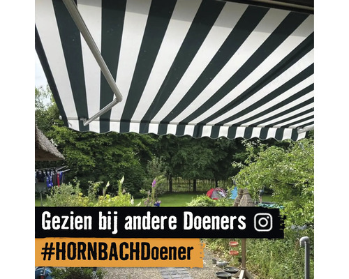 Gestreepte zonwering boven een terras in een rijk beplante tuin.