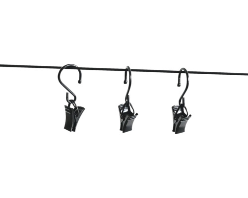 Drie zwarte metalen gordijnknijpers met haken, hangend aan een dunne stang.