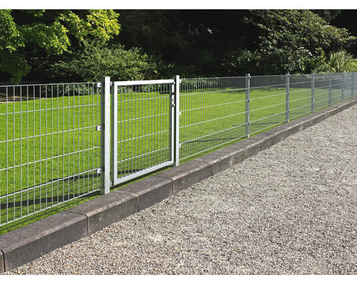 Verzinkt dubbelstaafmathekwerk met bijpassende tuinpoort op een gazon langs een grindpad.