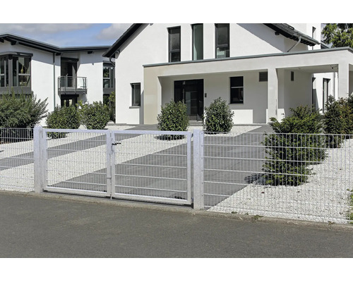 Dubbele dubbelstaafmatpoort en bijpassend hekwerk voor een modern woonhuis met grindtuin en struiken.