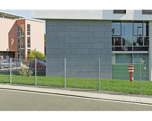 Dubbelstaafmathekwerk van metaal op een gazon voor een modern kantoorgebouw.