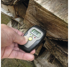 Houtvochtmeter meet het vochtgehalte van haardhout in een stapel hout.