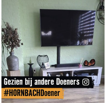 Moderne woonkamer met televisie aan een groene bakstenen muur boven een licht houten tv-meubel.