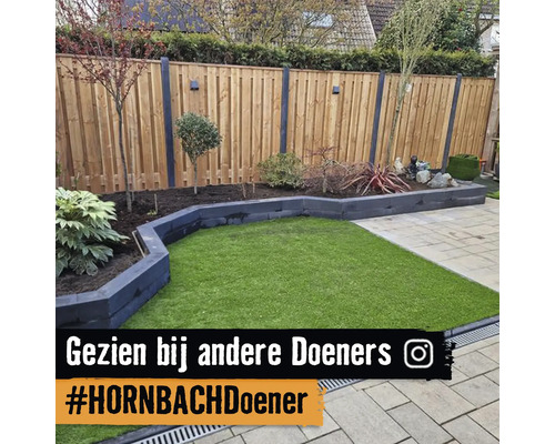 Georganiseerde tuin met houten schutting, border van steen, gazon en bestrating. Instagram Logo.