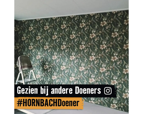 Wand met behang met bloemenpatroon naast een trapladder.