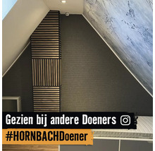 Moderne zolderkamer met decoratieve houten lattenwandpanelen in horizontale en verticale patronen tegen een donkere wand met textuur.