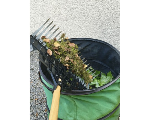 Tuinhark met verzameld blad boven een tuinafvalzak