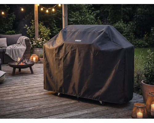 Tenneker barbecuehoes op een houten terras naast een brandende vuurschaal en tuinmeubilair bij schemering.