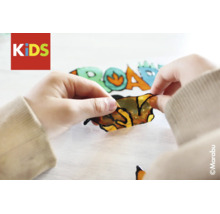 Kinderhanden maken een raamverfsticker met dinosauruspatroon los. Marabu Logo en KIDS Logo.