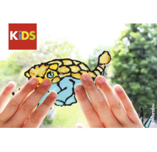 Kinderhanden raken een met Marabu KIDS Window Color gemaakt vismotief op een ruit aan. Marabu Logo.